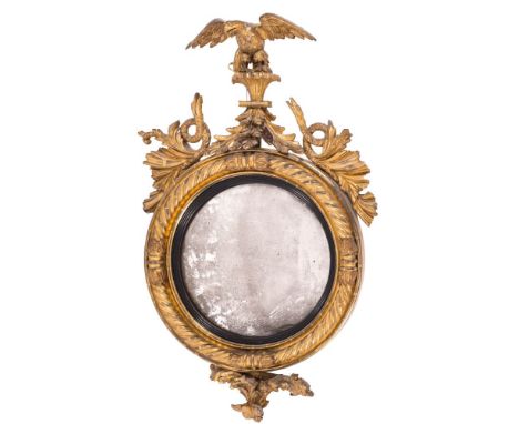 A Regency carved giltwood and gesso circular convex mirror,: the surmount with an eagle with outspread wings perched on a ree