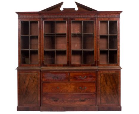 A 19th century mahogany breakfront library bookcase,: the upper part with an architectural broken pediment, moulded dentil co