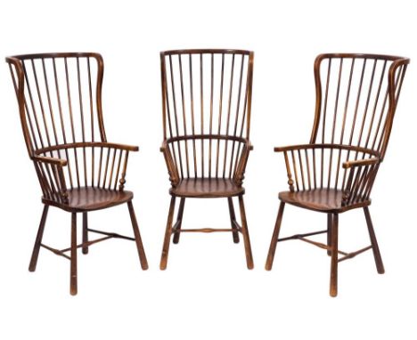 A set of three ash, fruitwood and beech stick back Windsor wing armchairs:, with curved backs, shaped arm supports and shaped