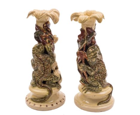 Two Alexander Lauder (Barnstaple) pottery grotesque candlesticks: each modelled with a warty lizard-like creature climbing a 