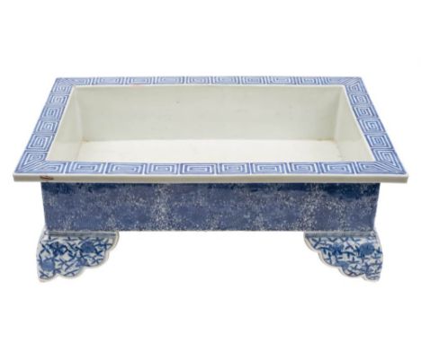 A large Japanese blue and white rectangular jardiniere: painted with a key pattern to the flattened rim, the sides with flowe