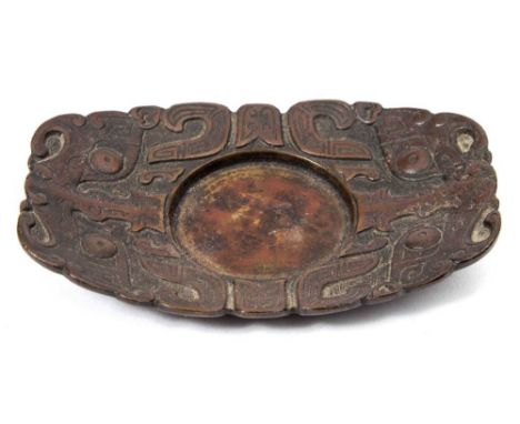 A Chinese bronze cup stand: of rounded rectangular form cast with taotie masks on a leiwen ground, two-character mark, 11 x 7
