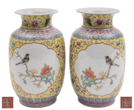 A pair of Chinese famille rose vases: each painted with two lotus panels of birds perched on flowering branches on a yellow g