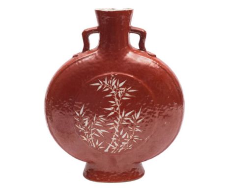 A Chinese coral ground moon flask: the short branch handles with ruyi-head terminals, each side with a raised panel decorated
