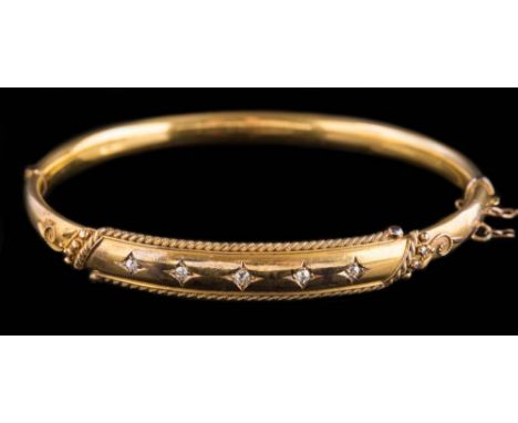 A late 19th century 15ct gold and diamond hinged bangle: with five square-set round old brilliant-cut diamonds, approximately