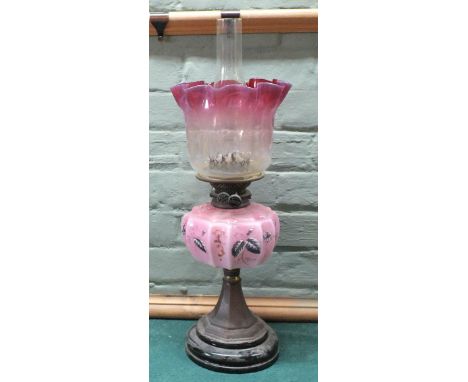 A brass column oil lamp with pink floral bowl and shade