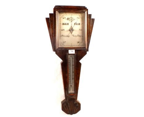 An aneroid barometer in Art Deco carved oak case