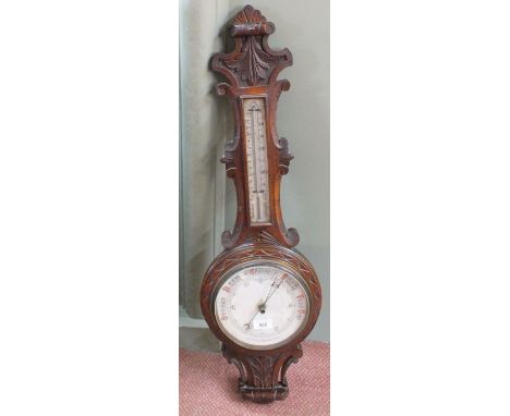 A carved oak aneroid barometer