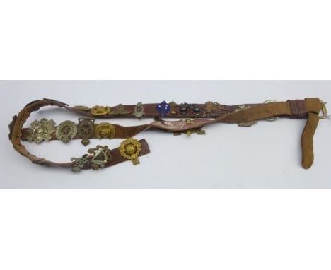 Two leather straps mounted with twenty-five Glengarry and cap badges, collar dogs etc including Royal Scots Greys, Green Howa