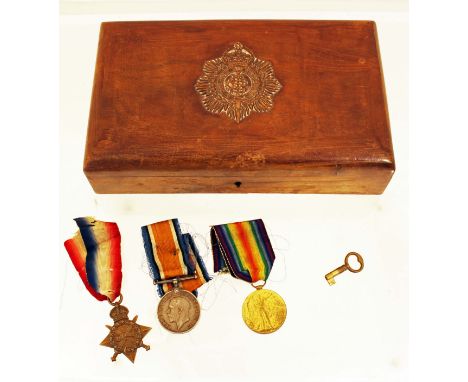 A WW1 military medal trio awarded to M2-074093 Corporal JC Carney of the Army Service Corps with a large wooden cigarette box