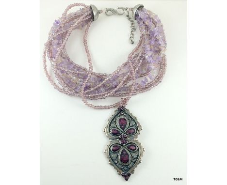 A silver designer necklace by Cesaree of Paris set with four rows of amethyst's
