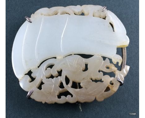 A carved Jade brooch in a white metal surround