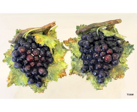 A pair of ceramic wall plaques of grapes