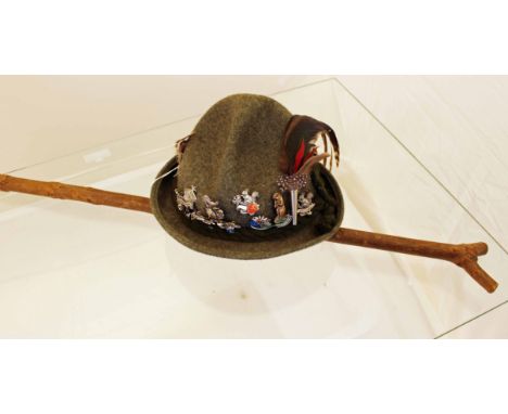 A vintage German mountaineering hat with 12 badges and a vintage wooden stalking stick