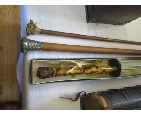 A Malacca and silver mounted walking cane, a swagger stick and a Japanese parasol with painted landscape silk canopy and bamb