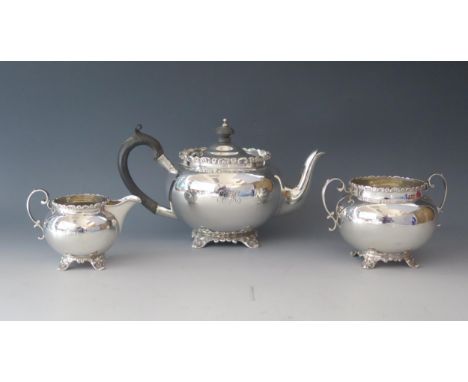 An Edward VII silver three-piece tea service, maker Barker Brothers, Chester 1909, monogrammed, of circular form, with floral