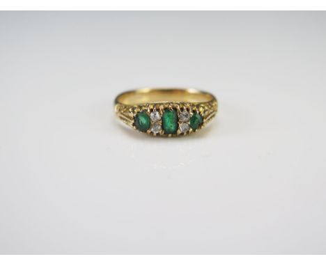 An Emerald and Diamond Seven Stone Ring in a precious yellow metal setting, c. 4.7x2.8mm principal stone and 1.9mm old cuts, 