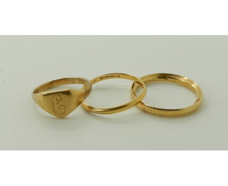 An 18ct wedding ring, size R1/2, a yellow metal signet ring size K, weight together 6.4gms and a 22ct gold wedding ring, size