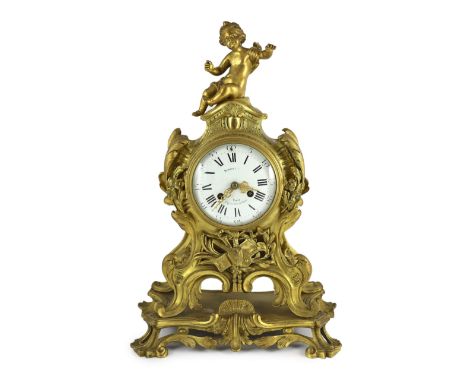 Bernoux of Paris. A 19th century Louis XV style ormolu mantel clock, with putto finial, enamelled Roman dial and scrolled cas