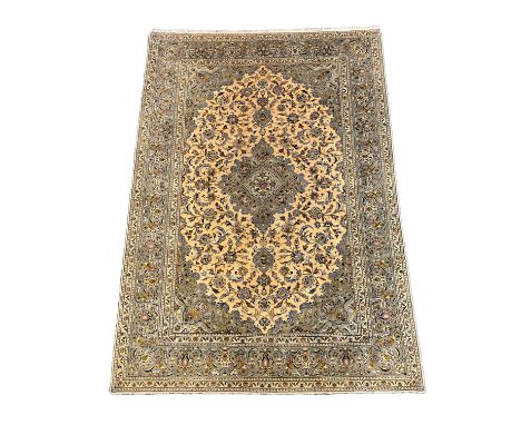 A Kashan ivory ground carpet, with central lobed floral medallion within a conforming field and wide multi border, 355cm x 24