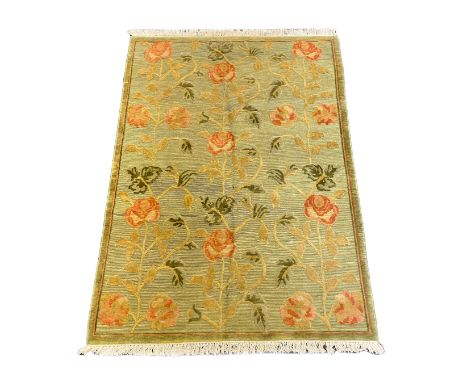 A Tibetan pale green ground carpet, with bold floral field, 250cm x 176cm***CONDITION REPORT***PLEASE NOTE:- Prospective buye