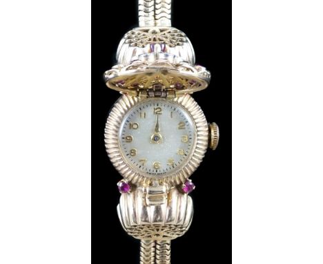 A lady's 1950's 9ct gold, ruby and diamond set manual wind cocktail watch, on a 9ct gold twin strand snake link bracelet, the