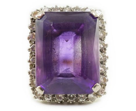 A large modern 18ct gold and emerald cut amethyst set dress ring, with diamond set border, the amethyst measuring approximate