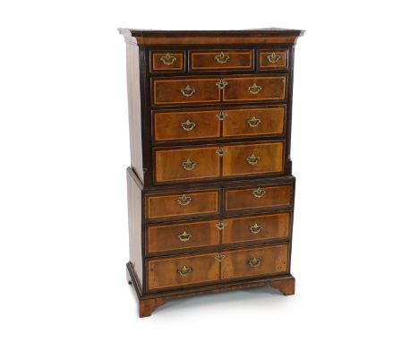A George II featherbanded walnut chest on chest, with moulded cornice, three short and three graduated long drawers over two 
