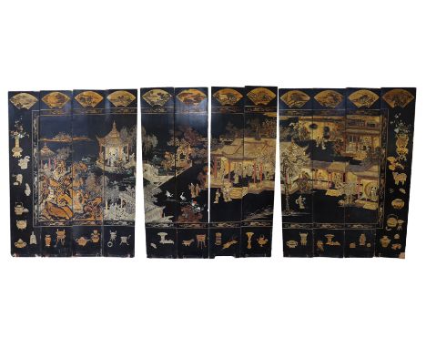 A tall Chinese coromandel lacquer twelve panel screen, 19th century, decorated with fan shaped panels over a continuous lands
