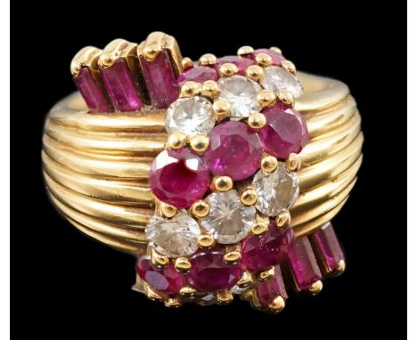 An early 1960's Kutchinsky 18ct gold ruby and diamond cluster set dress ring, with reeded shank and set with nine round cut d