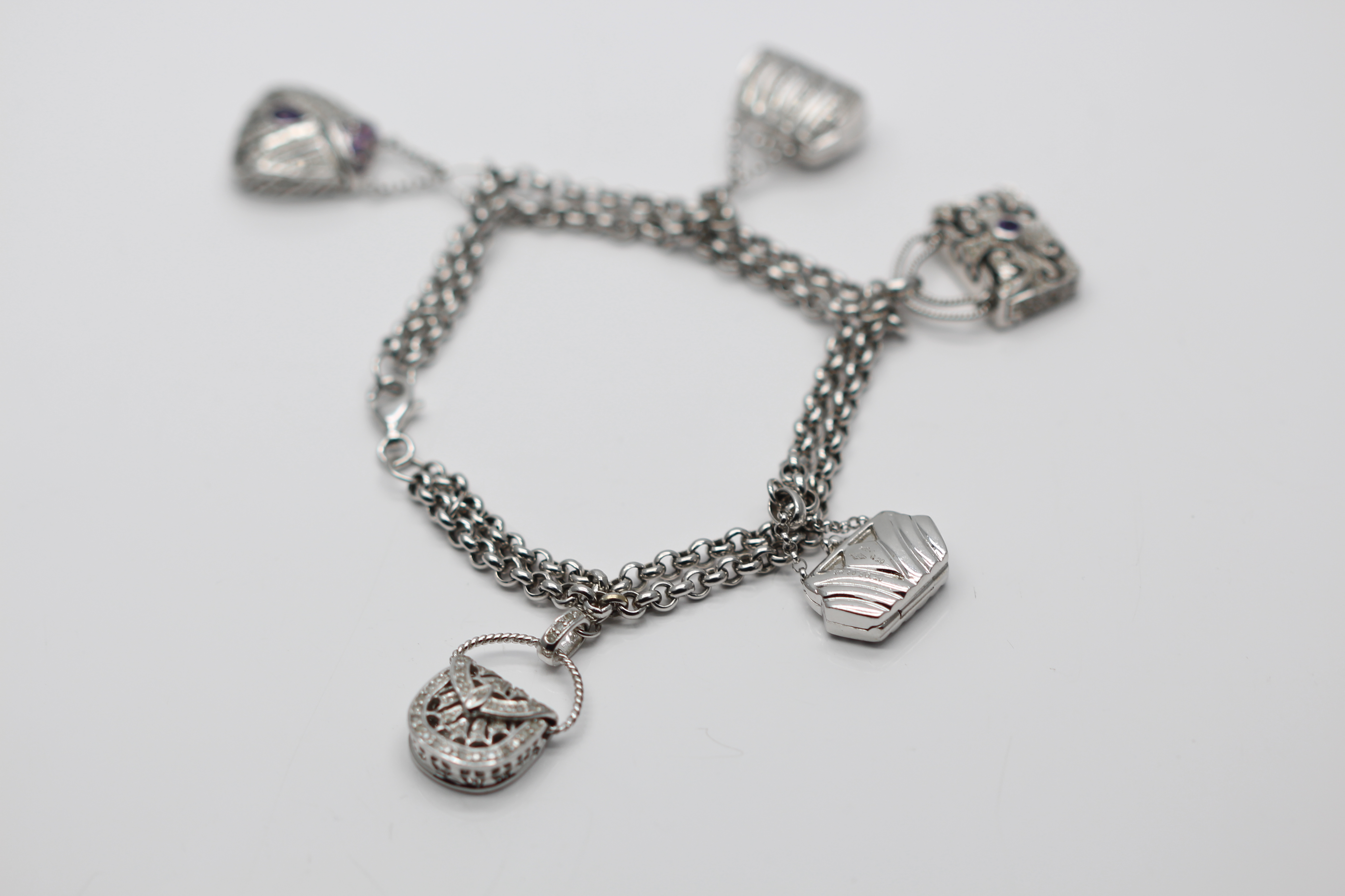 A BEAUTIFULLY CRAFTED 18CT WHITE GOLD CHARM BRACELET, SET WITH 5