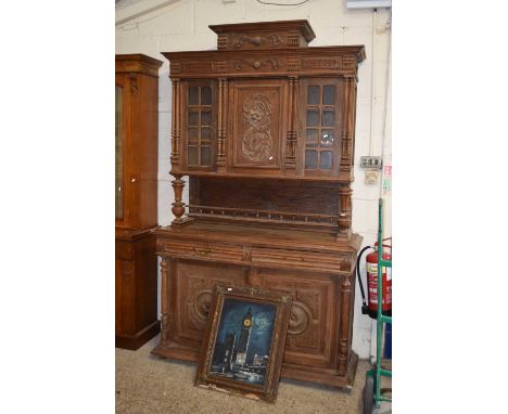 An oak buffet cabinet with glazed upper doors and carved door front panels