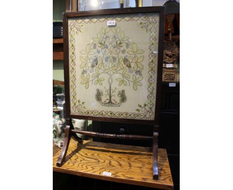 A GLAZED ARTS &amp; CRAFTS STYLE TAPESTRY depicting flora &amp; fauna, currently mounted as a firescreen 