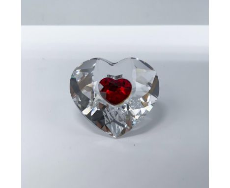 An exquisite clear crystal heart ornament, delicately adorned with a vibrant red interior heart, elegantly etched with the ye
