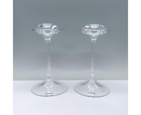 An elegant pair of clear candlesticks featuring a rounded base, a slender stem, and a cymbal-shaped top with a candle holder.