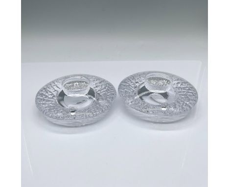 Designed by Lars Hellsten, a set of two votive candleholders with a smooth surface and a textured underside. Orrefors marked.