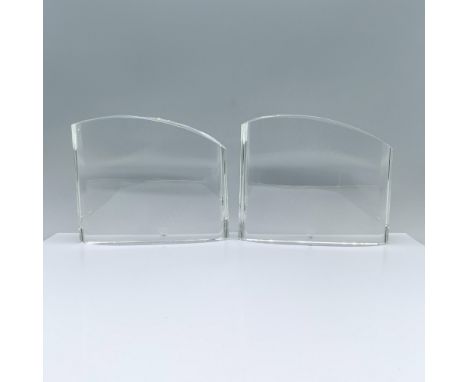 A pair of flat, rounded clear sculptures that feature a smooth arch top. Orrefors manufacturing sticker. Orrefors backstamp. 