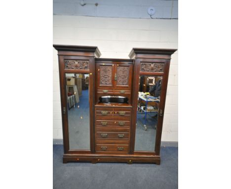 AN EDWARDIAN MAHOGANY COMPACTUM WARDROBE, with detailed foliate panels, two outer cupboard doors with bevelled mirror plates,