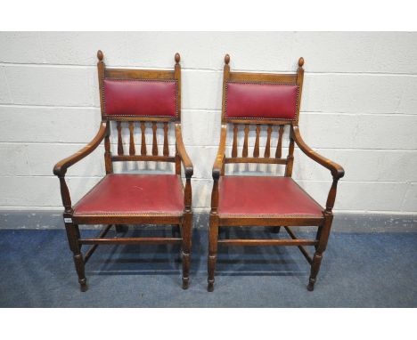 A PAIR OF ARTS AND CRAFTS STYLE OAK ARMCHAIRS, with open armrests, and red leatherette upholstery (condition:-repair to one f