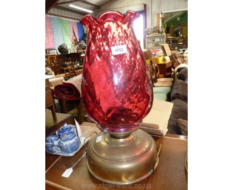 A church oil heater lamp with brass base and cranberry shade, fluted rim with chimney, 19 1/2" tall.