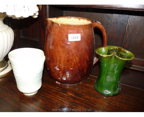 A brown and glazed pottery ale jug, green glazed trefoil vase, both with some chips and a pottery pitcher.