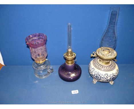 Three oil Lamps, one having squat ceramic bulbous base (hairline crack), three scroll feet, printed blue and white sunflowers