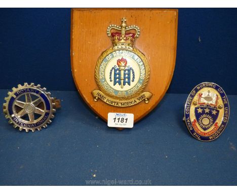 Two car badges for Rotary International and the College of Nursing and a wooden plaque for the School of Recruit Training Roy