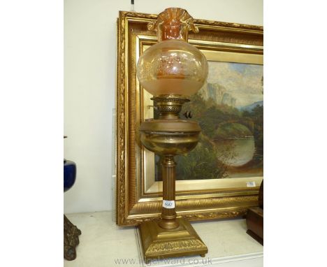 A brass oil Lamp with Corinthian column base, brass reservoir, amber fluted and etched shade, orange coloured chimney, double