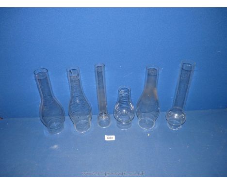 Six assorted oil lamp chimneys, various sizes.