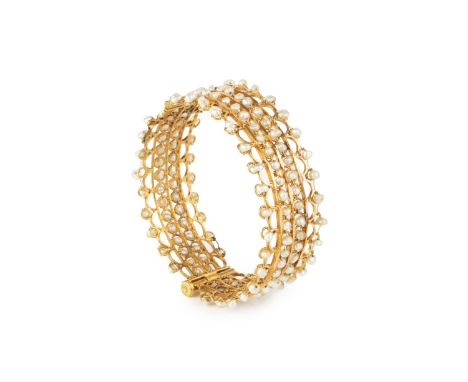 An Eastern yellow precious metal and seed pearl bangle, of hinged openwork design, set throughout with baroque seed pearls (u