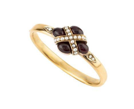 A garnet and half pearl bangle, designed as a quatrefoil of oval cabochon garnets enclosing a cross-shaped channel of half pe