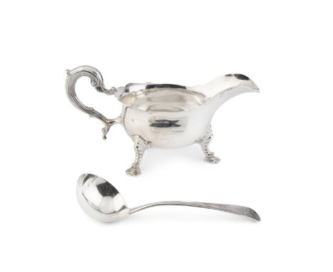 A George V silver sauce boat, with shaped border, scroll handle and shaped pad feet by Nayler Bros, London 1923, 21cm long, t