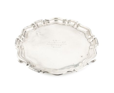 An Edwardian silver salver, with shaped border on scroll feet, presentation inscription, by Holland, Aldwinckle &amp; Slater,