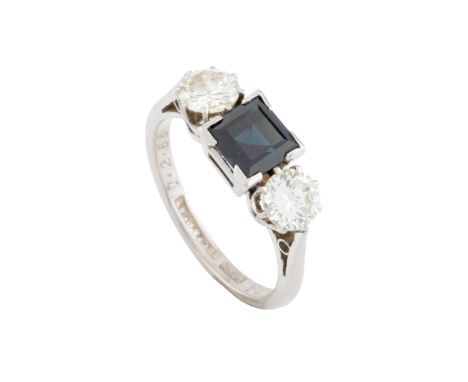 A sapphire and diamond three stone ring, the square step-cut sapphire claw set between two round brilliant-cut diamonds, with